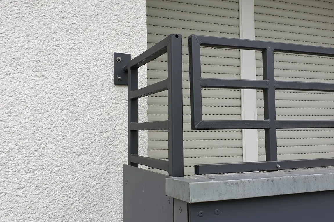 Neues anthrazitfarbenes Balkongel&auml;nder mit verschraubter Wandplatte an einem Wohnhaus