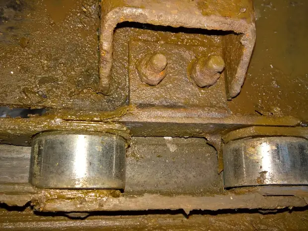Detail der Laufrollen eines Kettenf&ouml;rderers unter Anhaftungen